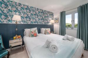 a bedroom with a large bed with towels on it at Blue Water in St Ives