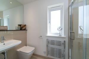a bathroom with a toilet and a sink and a shower at Blue Water in St Ives