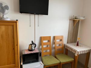 kuchnia z dwoma krzesłami i telewizor na ścianie w obiekcie Rybářská restaurace a penzion u Horáků w mieście Uničov