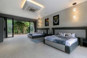 a bedroom with two beds and a couch in it at Colossus by StayVista - Riverside luxury villa in Khalapur with a Spacious pool, Sauna, Private theater, Gazebo & Lawn in Lonavala +35 photos