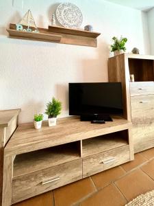 telewizor w drewnianym centrum rozrywki w salonie w obiekcie Apartamento en el casco histórico, a 5 min playa. w mieście Conil de la Frontera +19 zdjęć