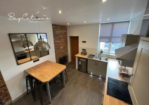 - une cuisine avec une table en bois et un comptoir dans l'établissement Stylish 2 bed Paignton apartment, 5 minute walk to beach, à Paignton