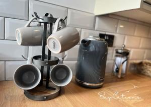 un grupo de tazas de café en una barra de cocina en Stylish 2 bed Paignton apartment, 5 minute walk to beach en Paignton
