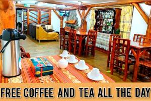 una sala de estar con una mesa con café y té. en Hotel Maderanegra By Huasicama en Latacunga