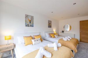 two beds in a room with yellow and white at Luxury 7 Bedroom House in Didsbury, Manchester in Manchester