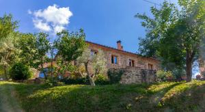 ein altes Steinhaus mit Bäumen davor in der Unterkunft La Limonaia in Monte San Savino