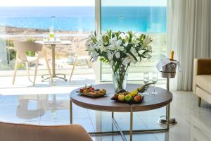 a vase of flowers and fruit on a table in a living room at Chrysomare Beach Hotel & Resort in Ayia Napa