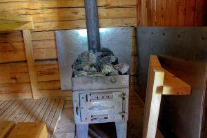 a stove with a pile of rocks in a cabin at Beautiful 4-5 persons Cottage in Alvdalen in Älvdalen