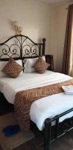 a bedroom with a large bed with brown and white pillows at Sochati Casa Resort in Nairobi