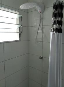 a bathroom with a shower curtain and a window at Pousada Seu Jorge in Campinas