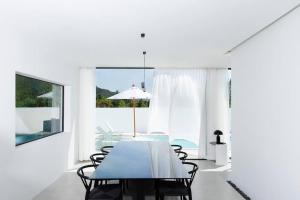 a dining room with a table and chairs and a window at HER HUAHIN POOL VILLA in Hua Hin