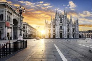 ミラノにあるLussuoso Attico con Garage Gratis vicino al Duomo e allo IEOの夕日を背景に広大な白い建物