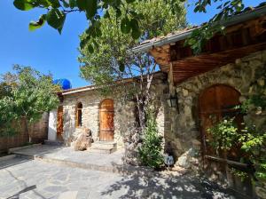 a stone house with a wooden door and a yard at safari house in Tbilisi City