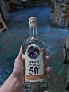 a person is holding a bottle of gin at safari house in Tbilisi City