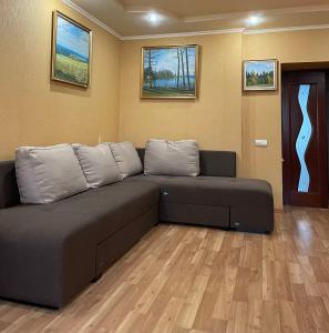 a couch in a living room with a wooden floor at Boryspil Airport Luxury apartment in Boryspil