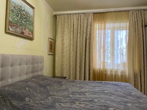 a bedroom with a bed and a window with curtains at Boryspil Airport Luxury apartment in Boryspilʼ