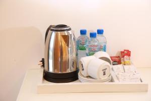 Ali Weta Safari Resort في اوداوالاوي: وعاء القهوة على رف مع زجاجات المياه