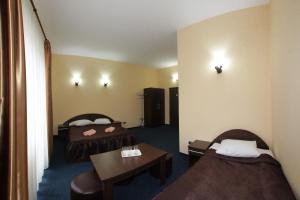 Habitación de hotel con 2 camas y mesa en Pensiunea COCO en Năsăud