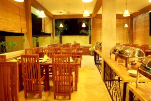 un restaurante vacío con mesas y sillas de madera en Ali Weta Safari Resort en Udawalawe