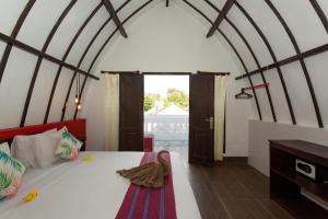 1 dormitorio con 1 cama en una habitación con ventana en Kidi's Lodge Gilitrawangan, en Gili Trawangan