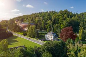 a building on the side of a road with trees at Penzion Vila Tereza in Hranice