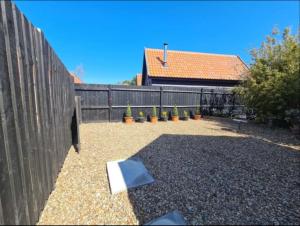 a backyard with a fence and a book on the ground at Middle Tree, ideal modern cottage in Alburgh