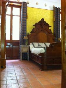 ein Schlafzimmer mit einem großen Holzbett in einem Zimmer in der Unterkunft Le Château De Conde En Barrois in Condé-en-Barrois