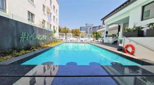 una piscina di fronte a un edificio di MINT Hotel 84 on Katherine a Johannesburg