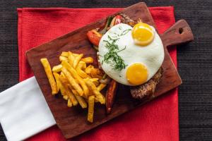 a plate of food with an egg and french fries at Hotel Los Ceibos in Tarija