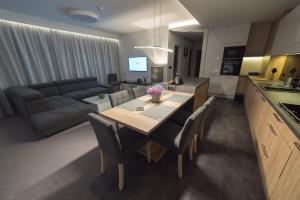eine Küche und ein Wohnzimmer mit einem Tisch und einem Sofa in der Unterkunft Apart-Hotel VIVI RESIDENCE & SPA in Żory