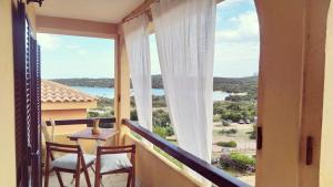 a balcony with a table and chairs and a view of the ocean at Sardegna Top Golfo Di Marinella in Golfo Aranci