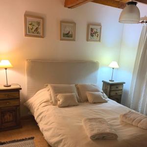 Un dormitorio con una gran cama blanca con dos lámparas. en Aleluya Patagónica, en Esquel