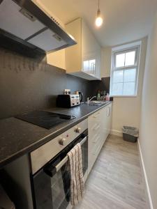 a kitchen with a stove top oven next to a sink at Midland road studio in Wellingborough