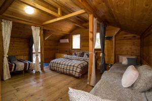 a room with two beds in a log cabin at Рибарник Forest Мagic in Topolitsa