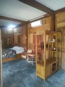 een kamer met houten kasten en een slaapkamer met een bed bij omah kayu jagalan in Magelang