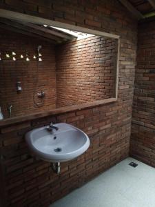 a bathroom with a sink and a brick wall at omah kayu jagalan in Magelang