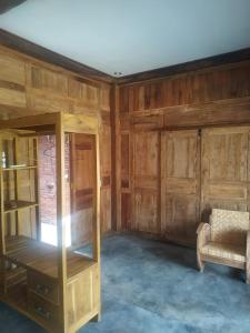 una stanza con pareti di legno, un divano e una sedia di omah kayu jagalan a Magelang
