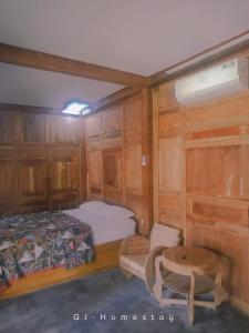 mały pokój z łóżkiem i stołem w obiekcie omah kayu jagalan w mieście Magelang