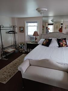 a bedroom with a large white bed and a window at The guest house at the regina house tea room in Moosic