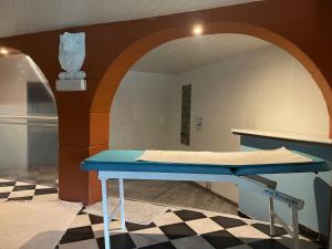 a blue table in a room with an archway at Chambres du Domaine Spa-piscine sauna in Lescout