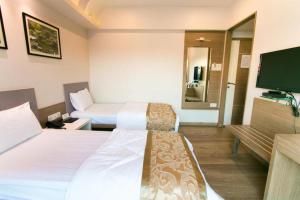 een hotelkamer met 2 bedden en een flatscreen-tv bij seasons hotel in Mire
