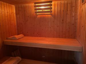 a wooden sauna with a wooden bench in it at Chambres du Domaine Spa-piscine sauna in Lescout