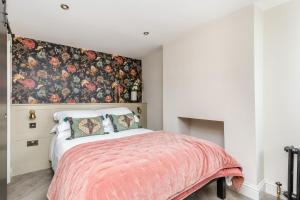 a bedroom with a bed with a floral accent wall at The Oak Rooms - Stylish & luxurious stay in Sussex by Huluki Sussex Stays in Hurstpierpoint