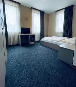 a room with a bed and a desk and windows at Hotel Residenz in Ansbach