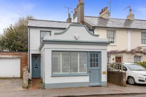 una casa blanca con una puerta azul y un coche en The Oak Rooms - Stylish & luxurious stay in Sussex by Huluki Sussex Stays en Hurstpierpoint