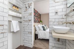 1 dormitorio con 1 cama y baño con lavabo. en The Oak Rooms - Stylish & luxurious stay in Sussex by Huluki Sussex Stays en Hurstpierpoint