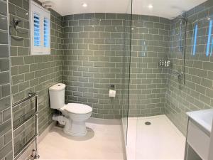 a bathroom with a toilet and a glass shower at Ferryman`s Cottage at The Beetle & Wedge in Moulsford