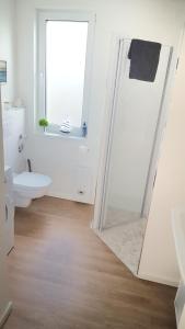a white bathroom with a shower and a toilet at Ferienwohnung Trave - Wohlfühlatmosphäre zum Auftanken in Bad Oldesloe