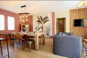 ein Esszimmer mit einem Tisch und einem Sofa in der Unterkunft Kaz Vavang magnifique villa 4 ETOILES in L'Étang-Salé-les-Bains