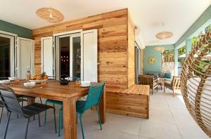 a dining room with a wooden table and chairs at Kaz Vavang magnifique villa 4 ETOILES piscine chauffée in Étang-Salé les Bains